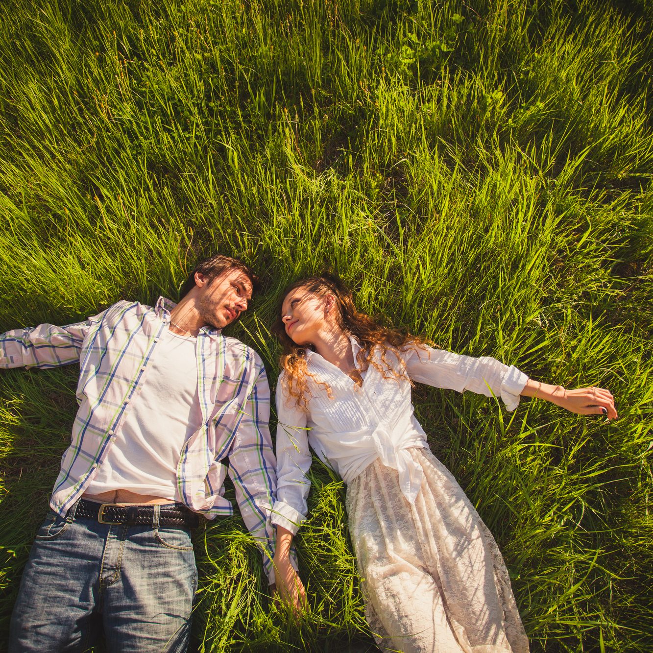 couple in love lying on green grass