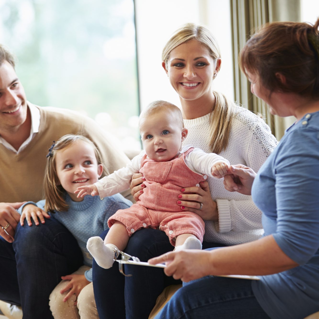 Health Visitor Talking To Family With Young Baby